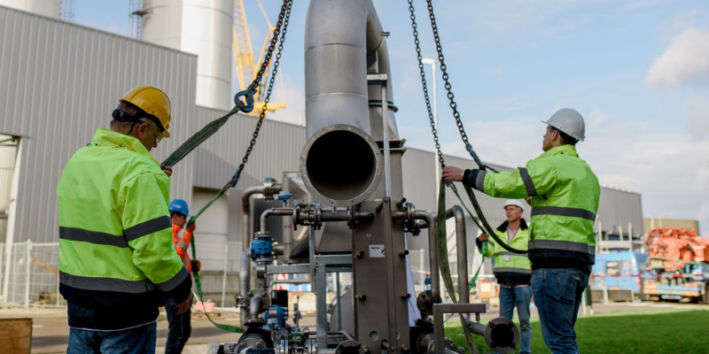 Engineers lifting major equipment into a customer site