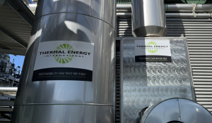 FLU-ACE heat recovery tower beside a HeatSponge unit with Thermal Energy International branding installed at an industrial manufacturing plant